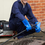 A man cleaning a main drain